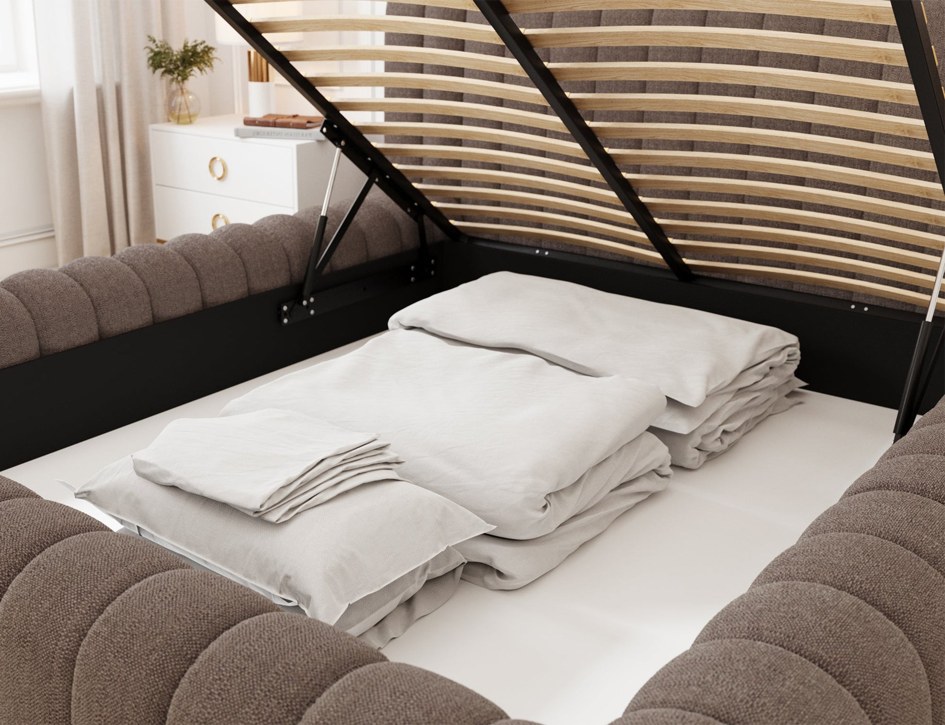 Pojemnik na pościel w łóżku Carilla Tonall 22 ciemnobeżowy z otwartym stelażem i złożoną pościelą w środku.