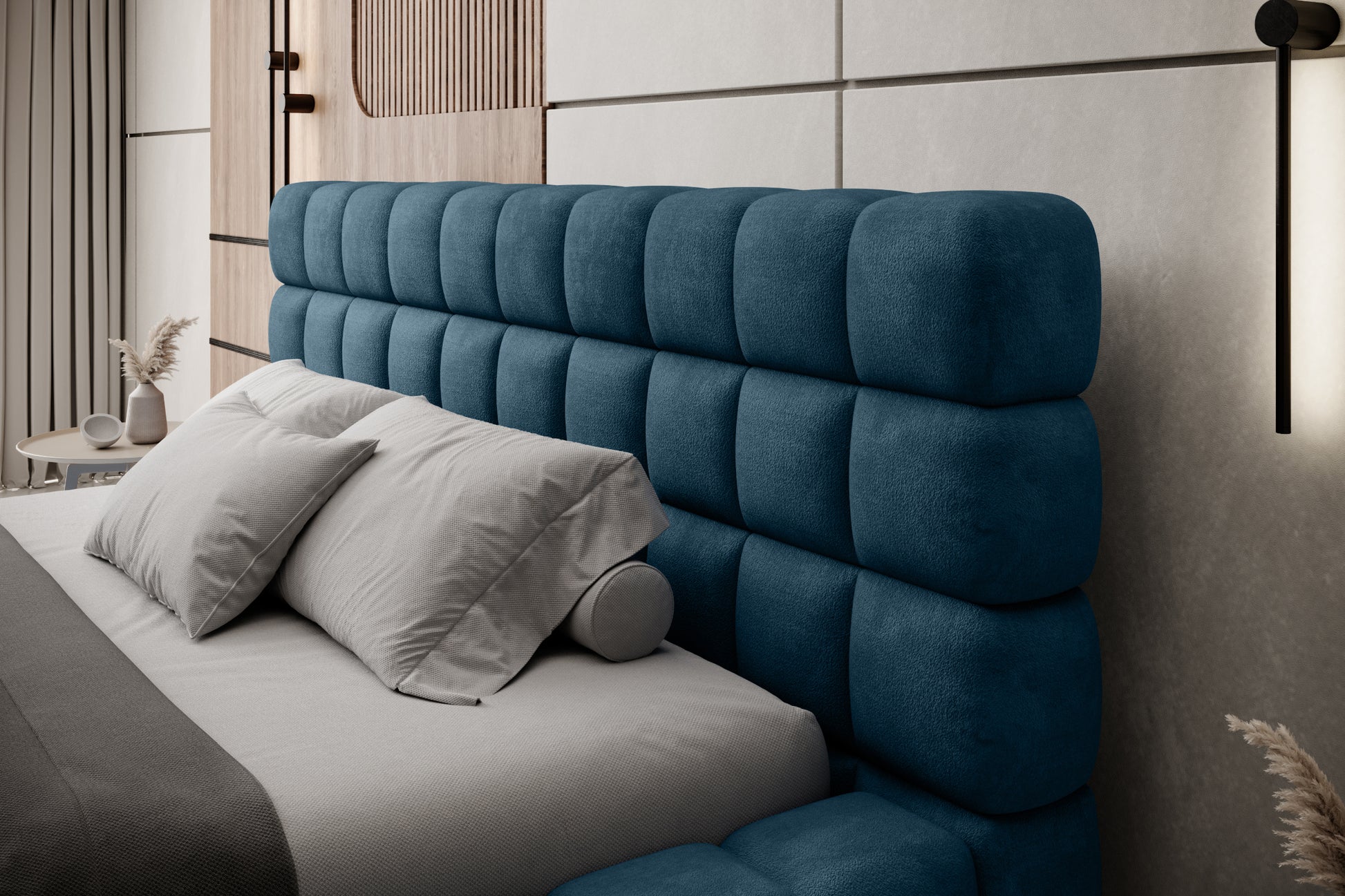 Zbliżenie na pikowany zagłówek łóżka Dizzle 160x200 cm w tkaninie Amore 40 granatowy, udekorowany poduszkami w nowoczesnej aranżacji sypialni.