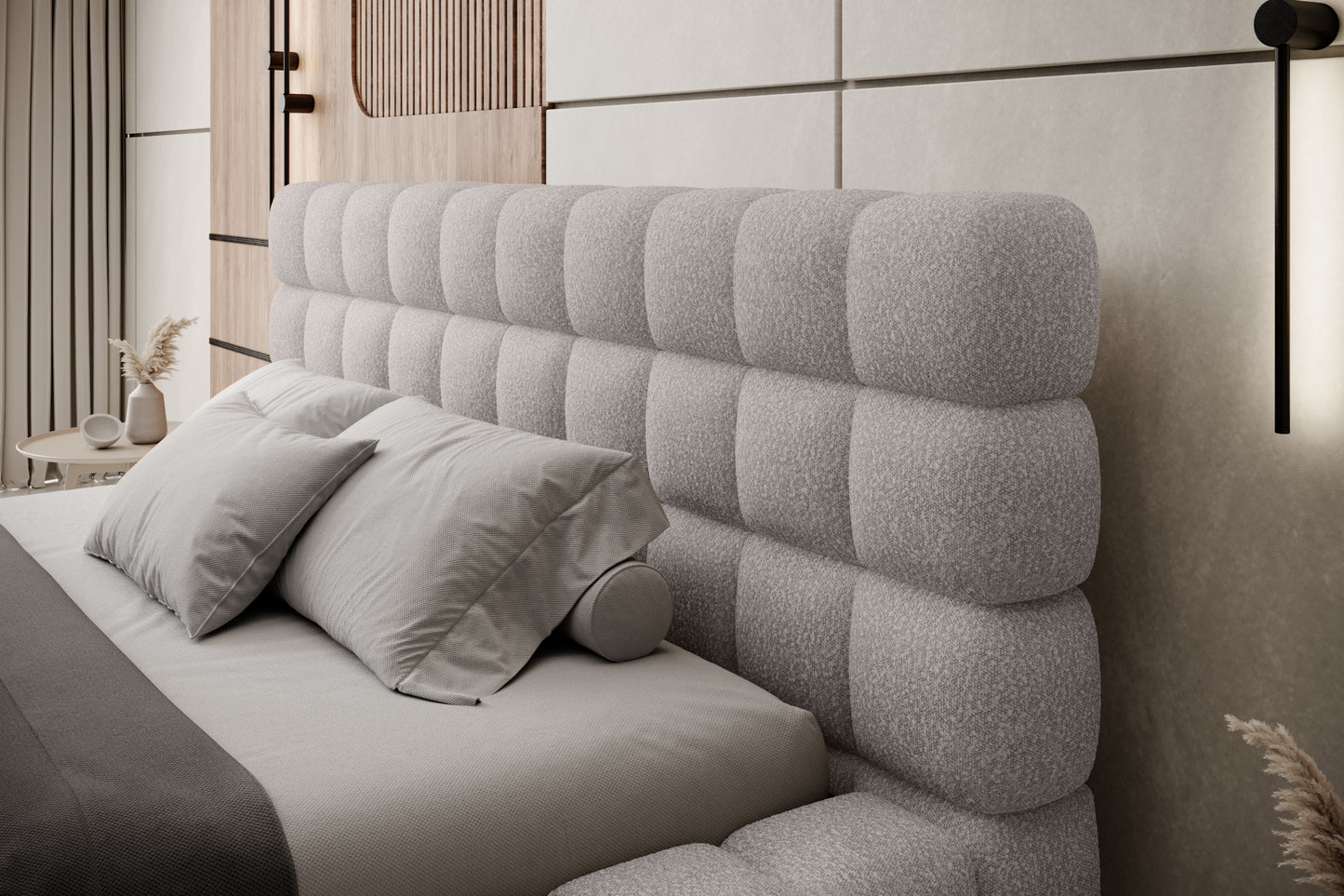 Zbliżenie na pikowany zagłówek łóżka Dizzle 160x200 cm w tkaninie Jaffray 03 szary, z eleganckimi poduszkami w nowoczesnej sypialni.