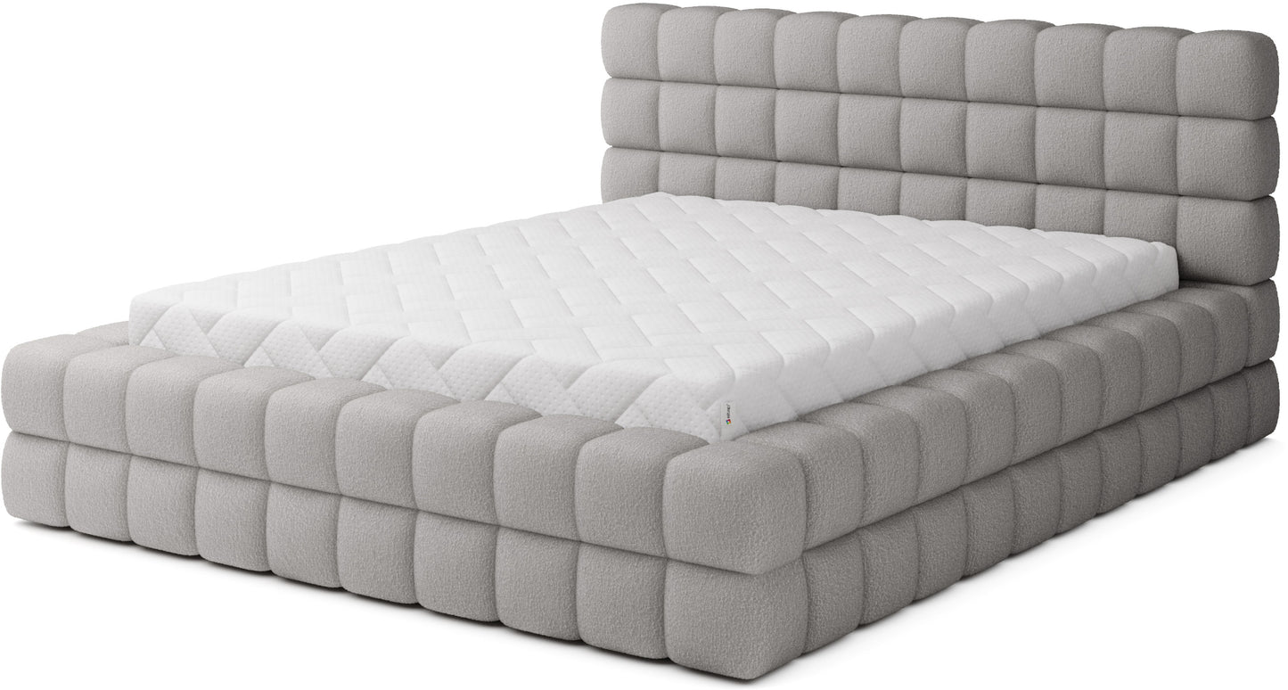 Łóżko tapicerowane Dizzle 140x200 cm w tkaninie Royal 04 szary, widok z przodu z masywną, pikowaną ramą i wysokim zagłówkiem.