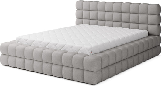 Łóżko tapicerowane Dizzle 140x200 cm w tkaninie Royal 04 szary, widok z przodu z masywną, pikowaną ramą i wysokim zagłówkiem.