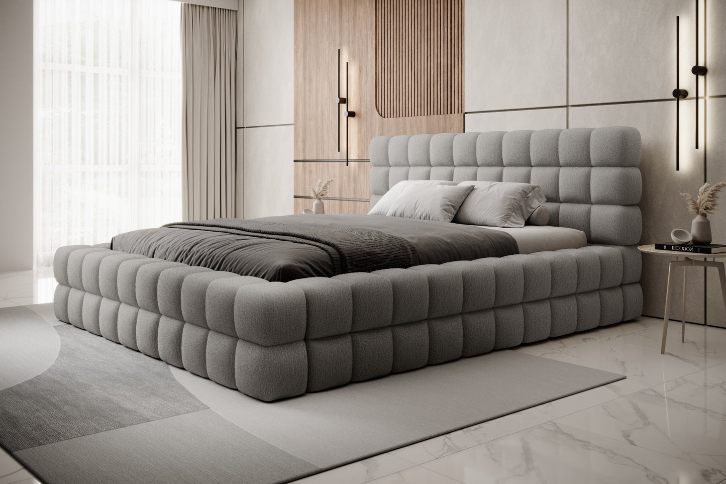Łóżko tapicerowane Dizzle 160x200 cm w tkaninie Royal 04 szary, ujęcie z boku w jasnym, minimalistycznym wnętrzu z dużymi oknami i szarym dywanem.