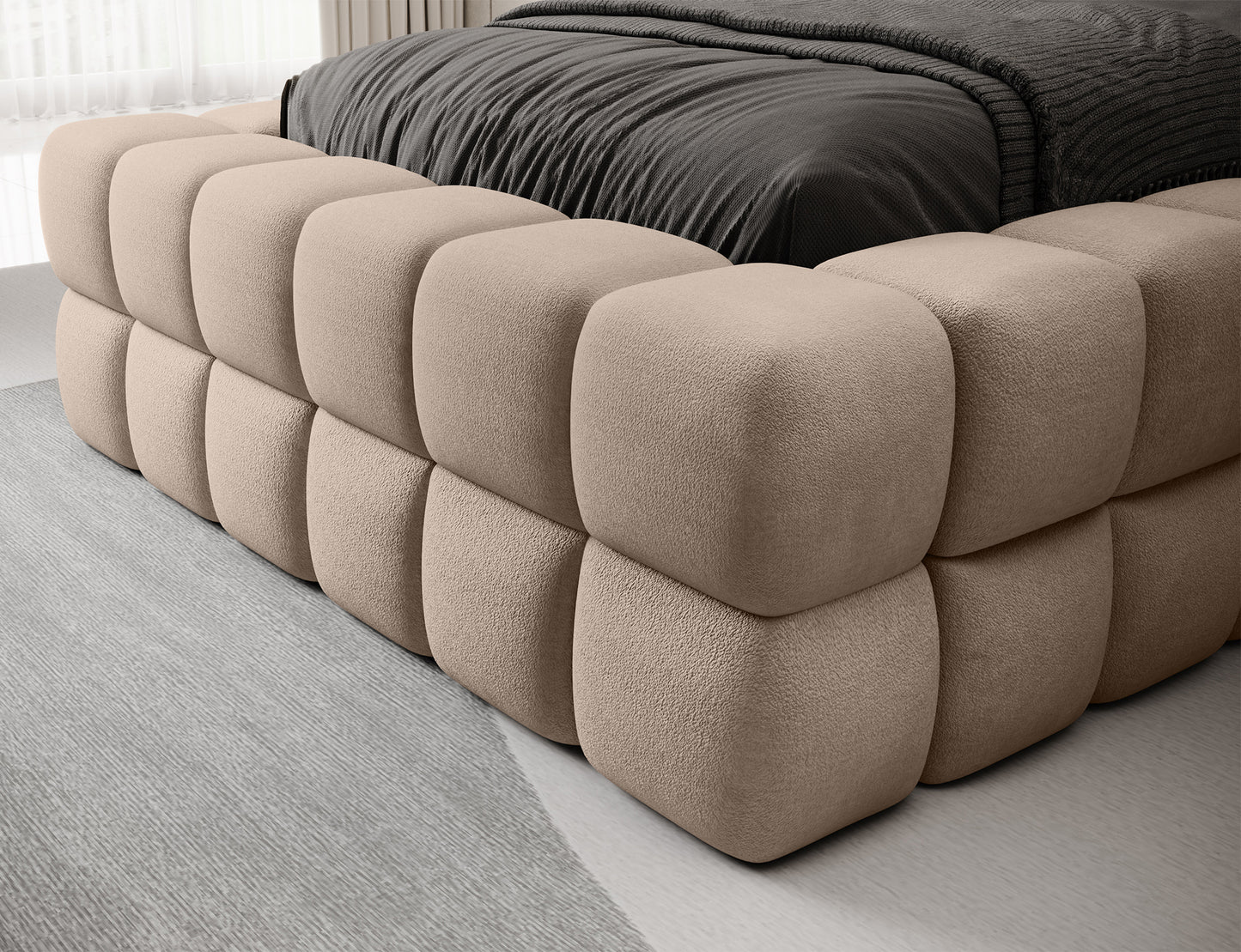 Zbliżenie na narożnik beżowego łóżka Dizzle 90 Amore 18, pokazujące miękkie, pikowane obicie w eleganckiej tkaninie.