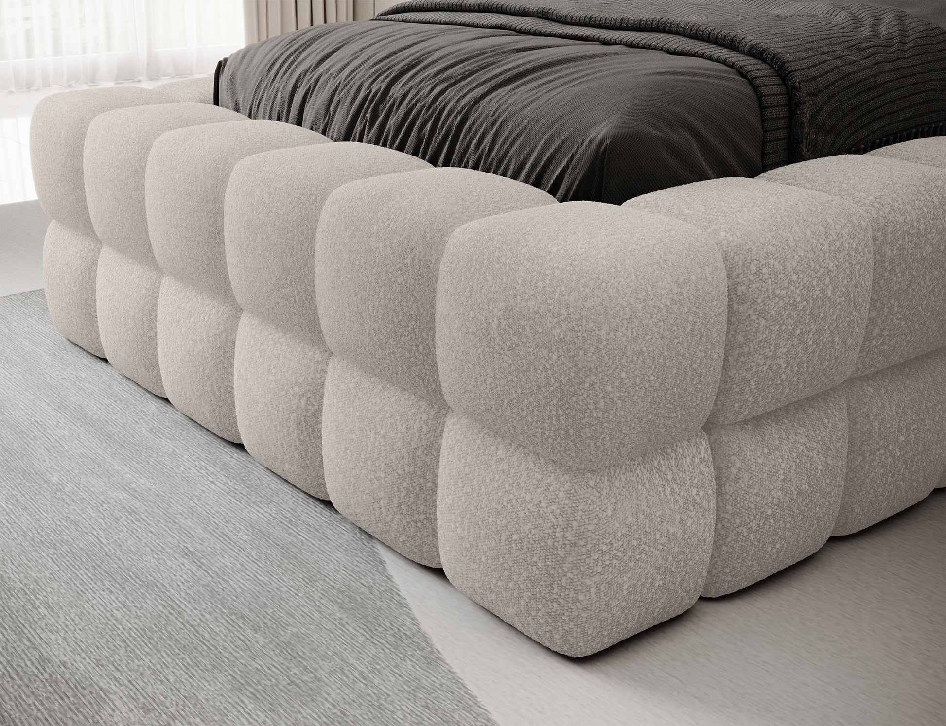 Detal łóżka Dizzle 90 w tkaninie Jaffray 18 jasnobeżowy, zbliżenie na tapicerowaną podstawę z charakterystycznym pikowaniem.