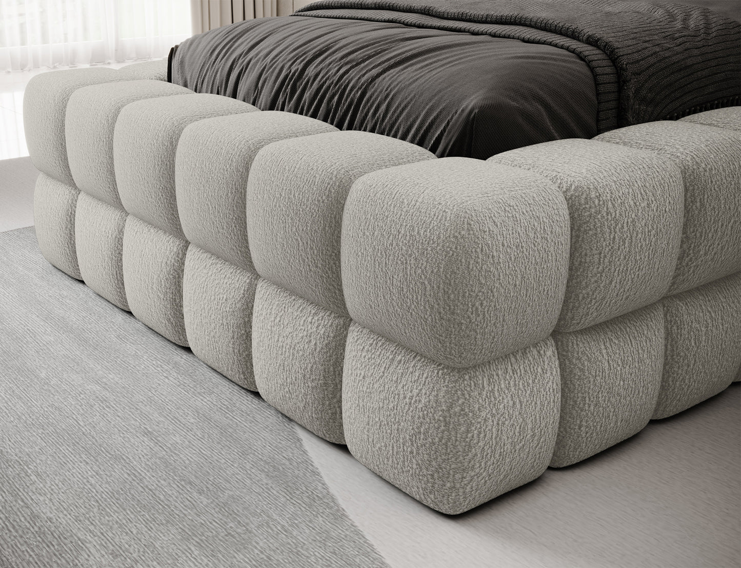 Detal tapicerowanego korpusu łóżka Dizzle I 90x200 w tkaninie Royal 20 beżowy, miękka powierzchnia o geometrycznym szyciu.