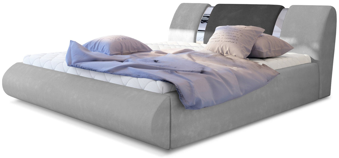 Nowoczesne łóżko tapicerowane Flavio w kolorze Paros 05 szary i Paros 06 ciemnoszary, rozmiar 140x200 cm, widok z przodu z pościelą w odcieniach fioletu i beżu.