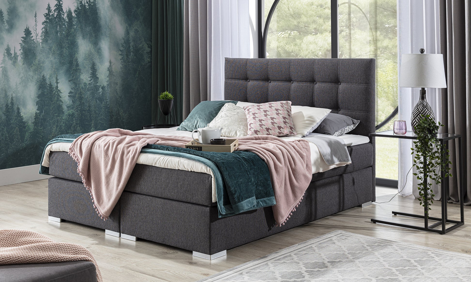 Łóżko kontynentalne Inez 140x200 cm w kolorze Inari 96 ciemnoszary w nowoczesnej sypialni z dużymi oknami i jasnym wystrojem wnętrza.