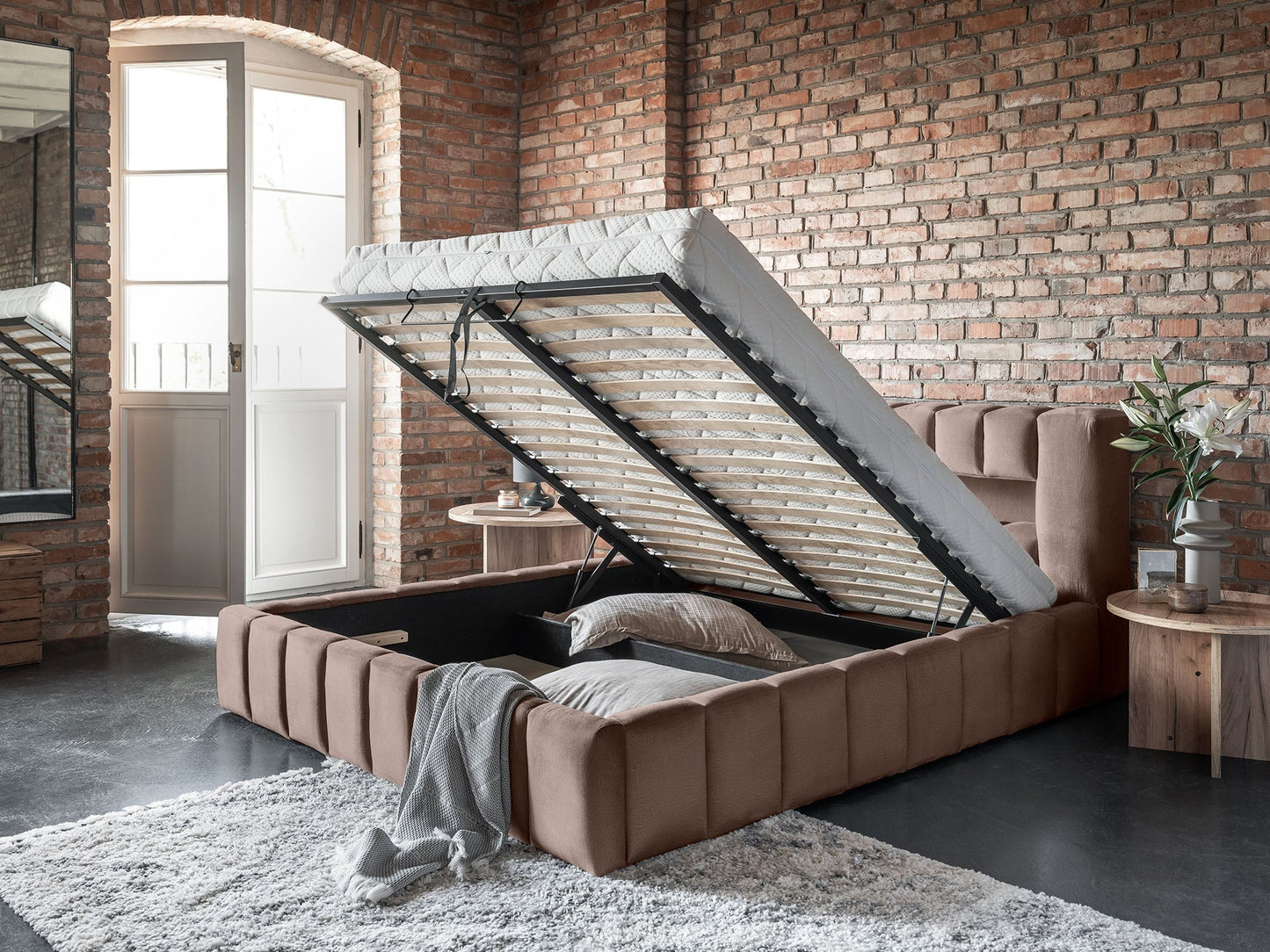 Perspektywa z boku na łóżko Lamica Monolith 09 piaskowy (140×200 cm) ze stelażem uniesionym ku górze, pokazująca pojemny schowek pod materacem.