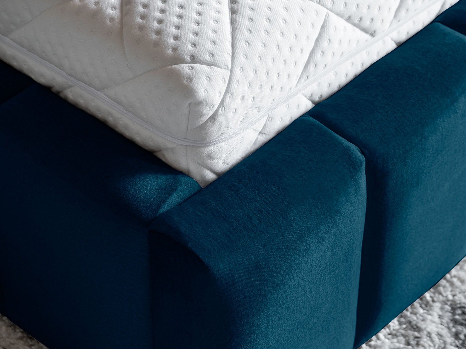 Detal narożnika łóżka Lamica 160x200, Monolith 77 granatowy — gładkie przeszycia i miękka krawędź.
