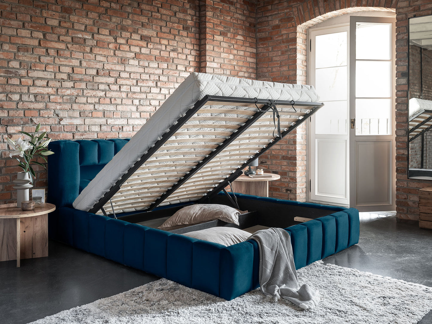 Otwarty pojemnik pod materacem w łóżku Lamica 160x200, Monolith 77 granatowy — ujęcie loftowe.