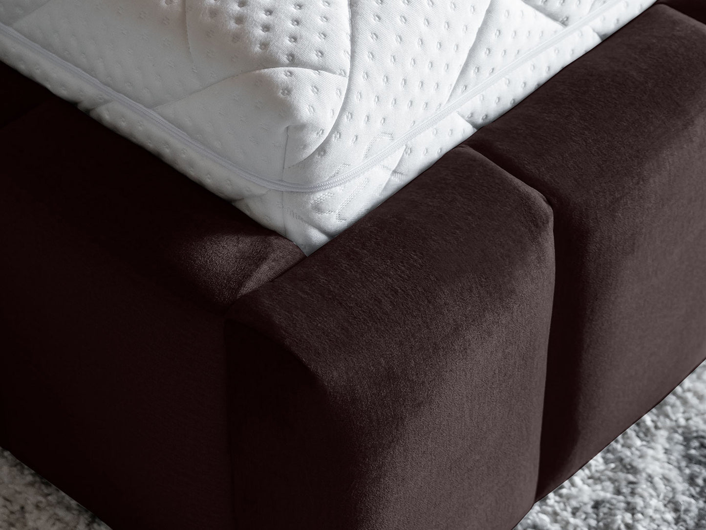 Zbliżenie na narożnik materaca i tapicerowaną ramę łóżka Lamica II Monolith 29 brązowy 140×200 cm.