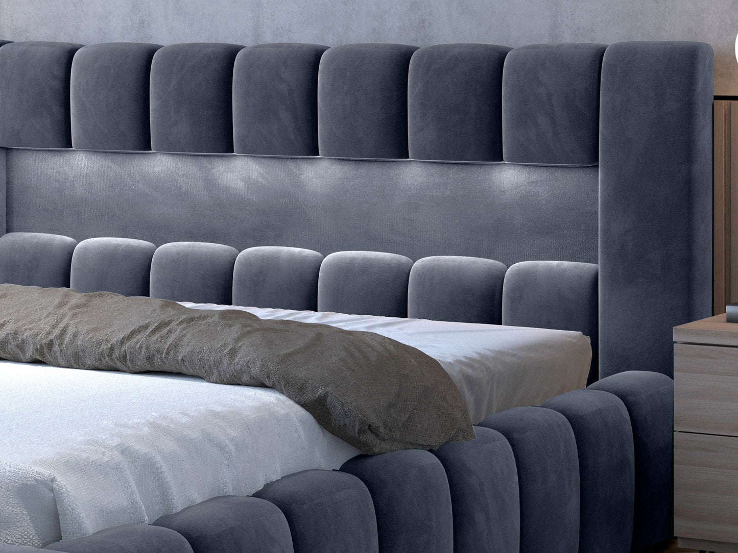 Zbliżenie na pikowany zagłówek łóżka Lamica II Monolith 97 ciemnoszary z subtelnym podświetleniem LED na tle ceglanej ściany.