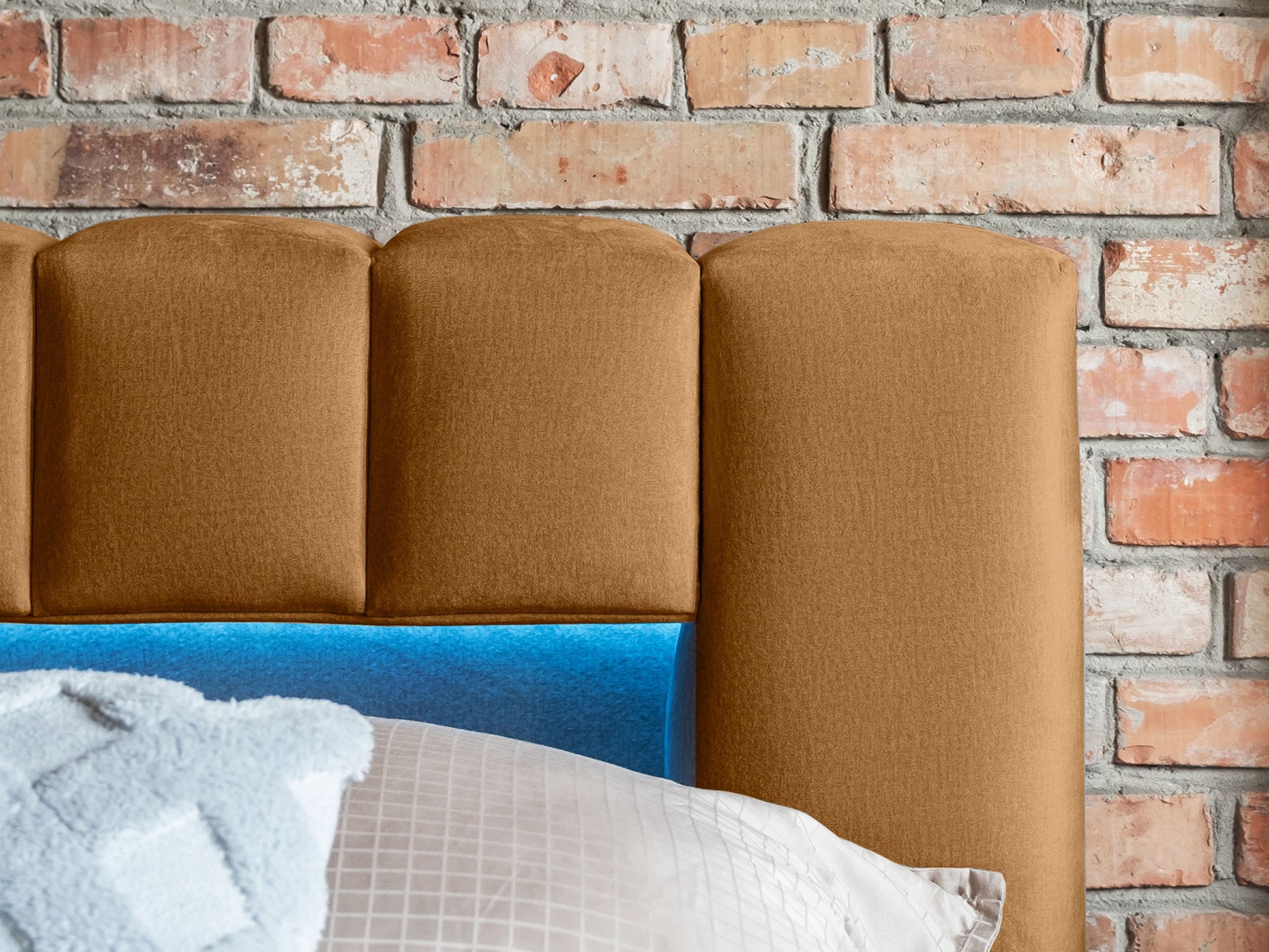 Zbliżenie na zagłówek łóżka Lamica II w kolorze miodowym z widocznym oświetleniem LED.