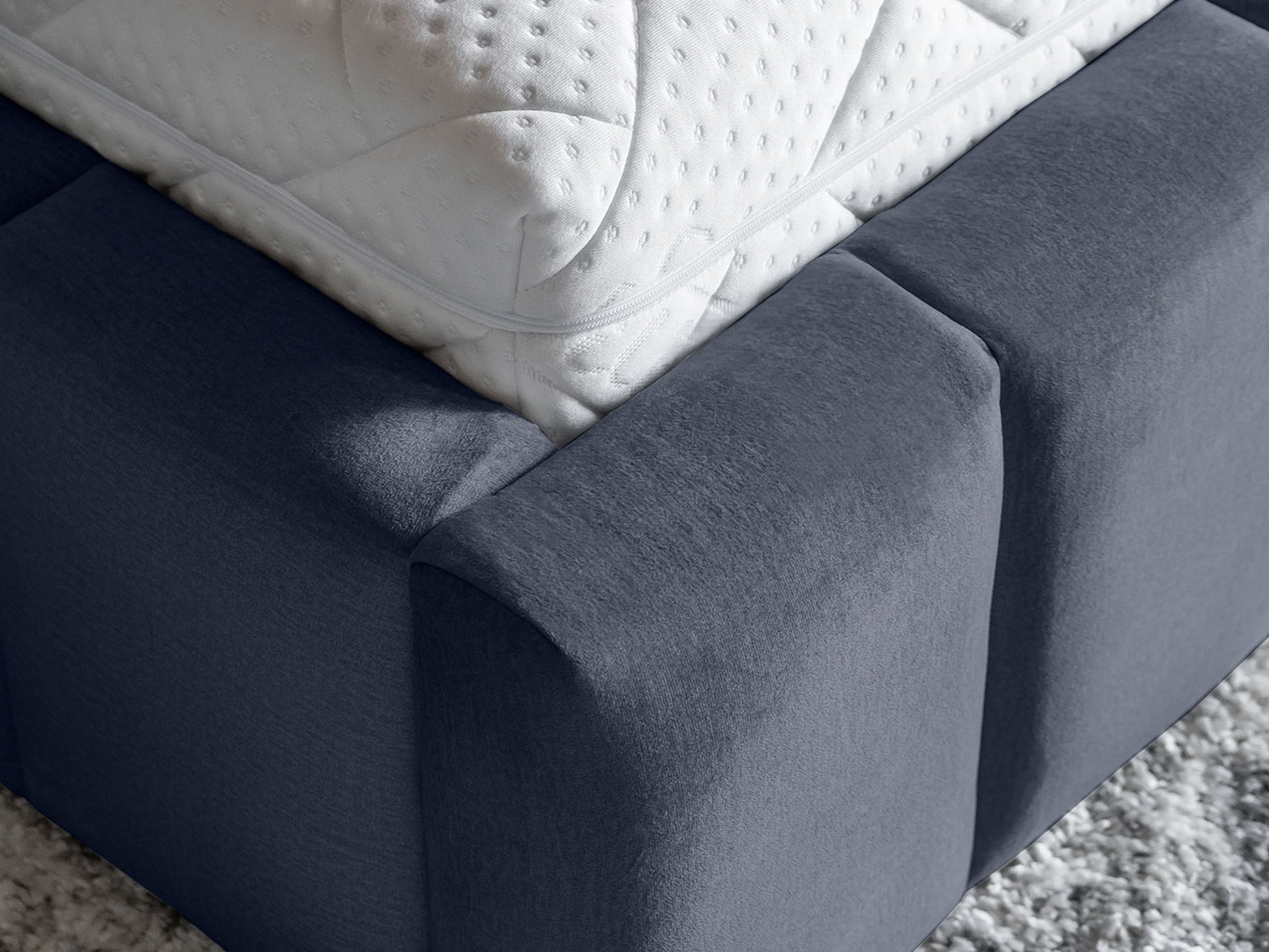 Narożnik ramy łóżka Lamica II 180x200 cm w kolorze Monolith 97 ciemnoszary, widok z góry na detal tapicerki i materac.