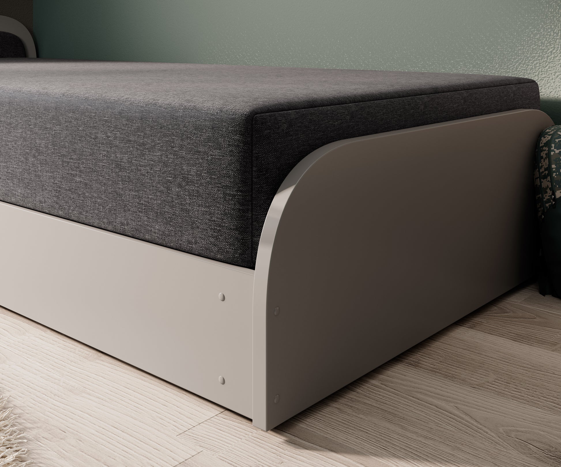 Obły front i materiały łóżka Parys I Sawana 05 ciemnoszary, widoczne połączenie tapicerki z korpusem na tle drewnianej podłogi.