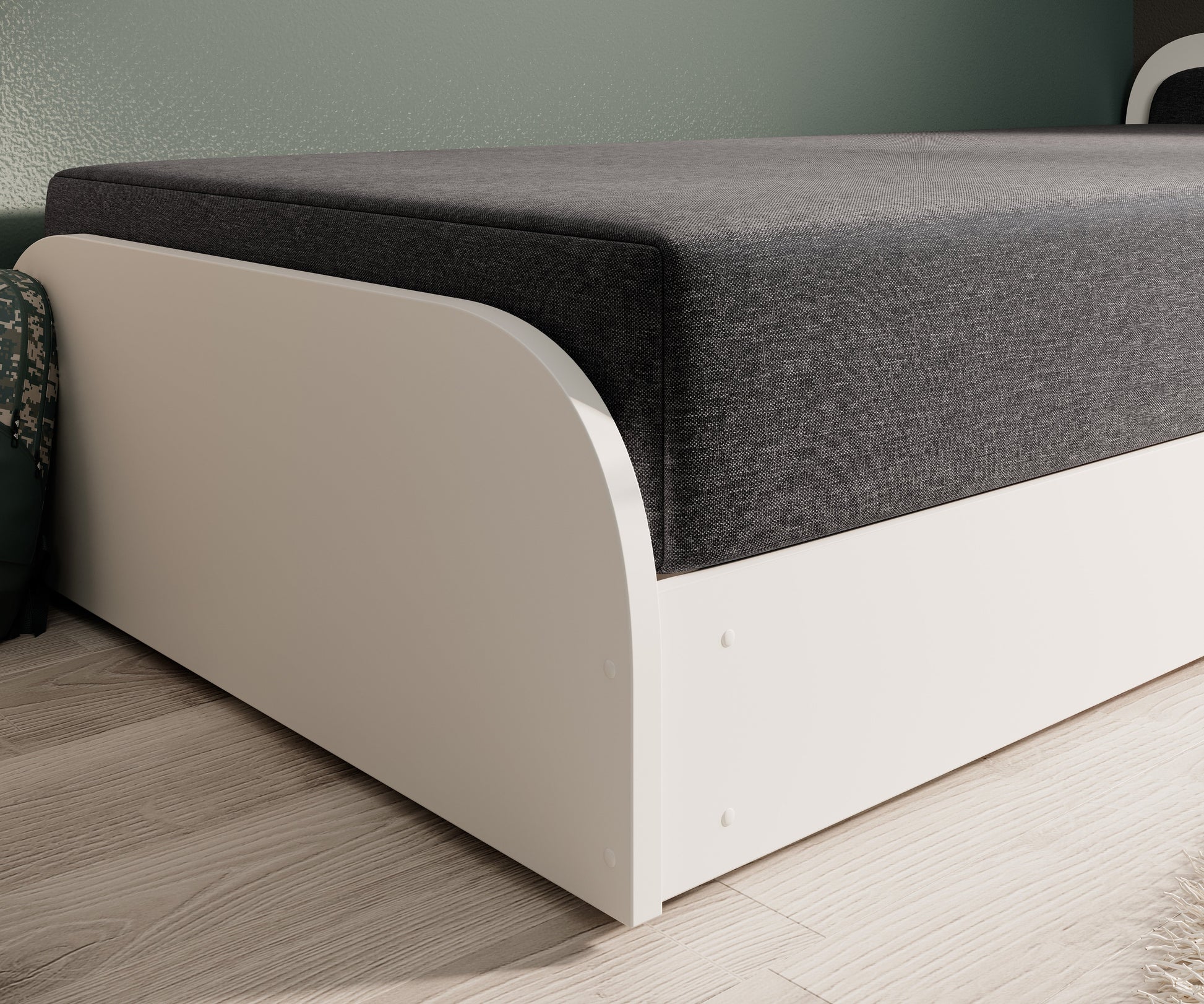 Detal dolnej części łóżka Parys I: zaokrąglona biała rama i ciemnoszary materiał Sawana 05, układ prawy.
