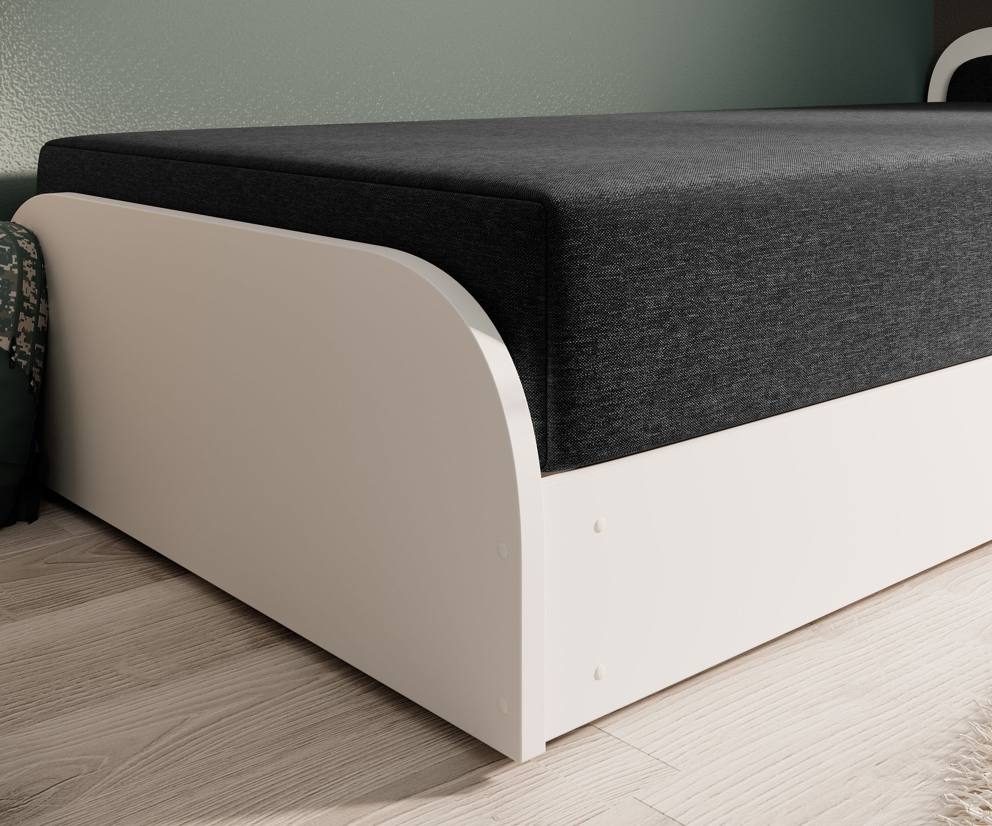 Zbliżenie na dolną ramę łóżka Parys I: biała, zaokrąglona płyta i ciemnoszary materiał Sawana 14, prawostronne wykończenie.