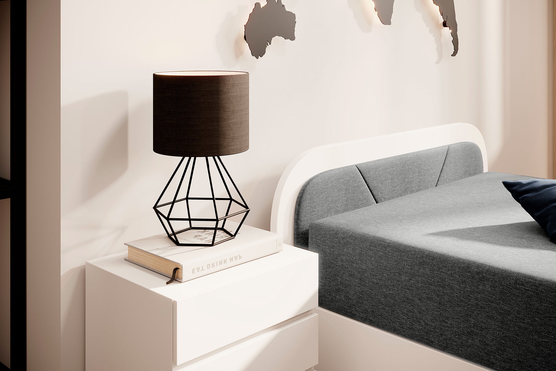 Zbliżenie na zagłówek łóżka Parys II: czarna tapicerka Sawana 21 w zaokrąglonej białej ramie obok białej szafki nocnej z lampą.