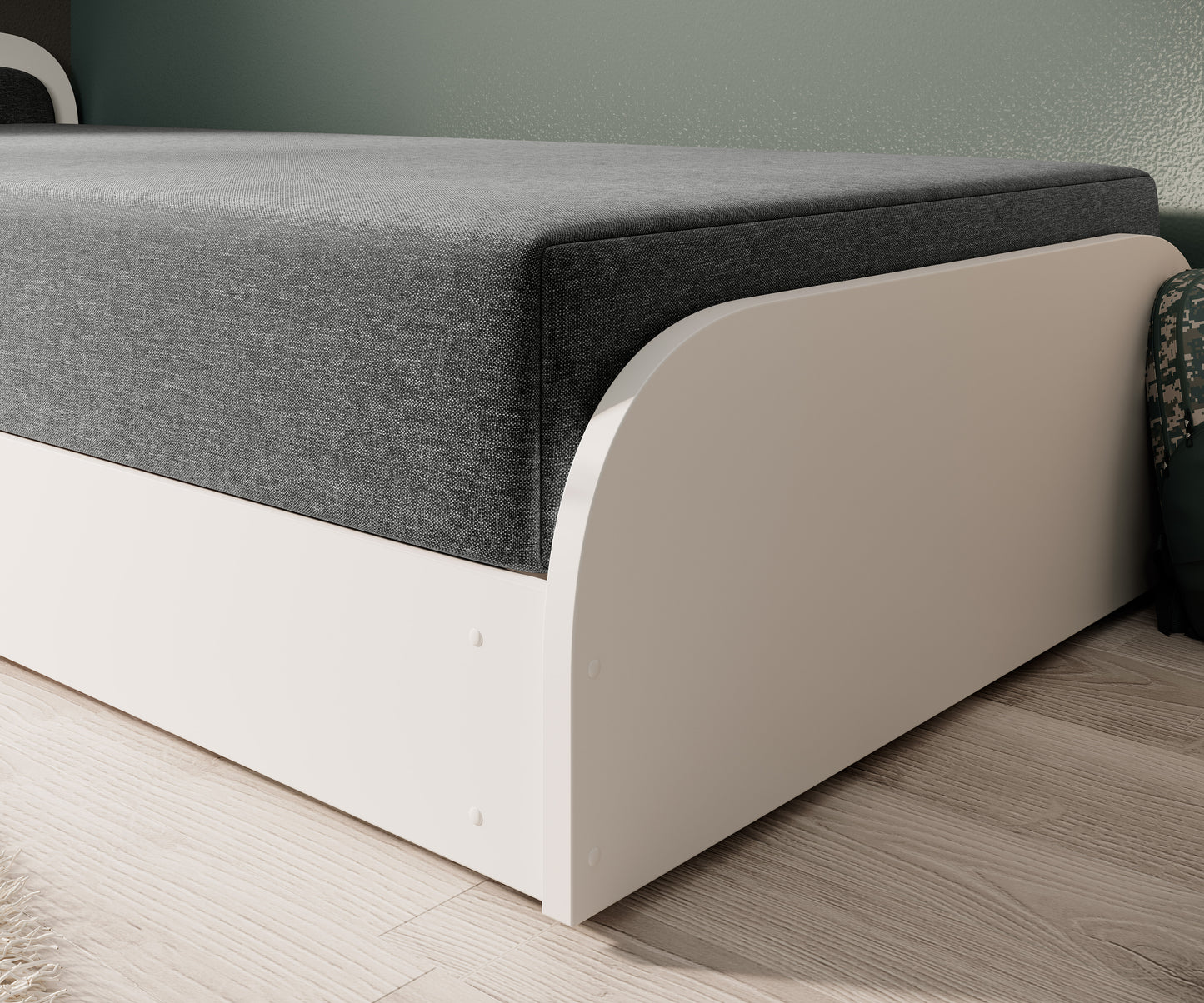 Detal dolnej krawędzi łóżka Parys II – zaokrąglona biała rama i szary tkanina Sawana 21 na tle jasnej podłogi.