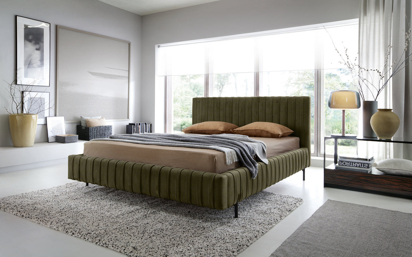 Łóżko Plissa 160×200 w kolorze Nube 33 jasnozielonym w nowoczesnej, jasnej sypialni przy dużym oknie, z beżową pościelą i stolikiem nocnym z lampą.