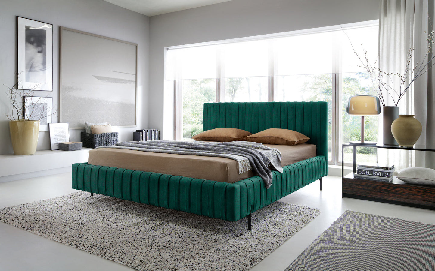 Łóżko Plissa 140×200 Nube 35 zielone ustawione w jasnej sypialni przy dużym oknie, z beżową pościelą i designerską lampą na szklanym stoliku nocnym.