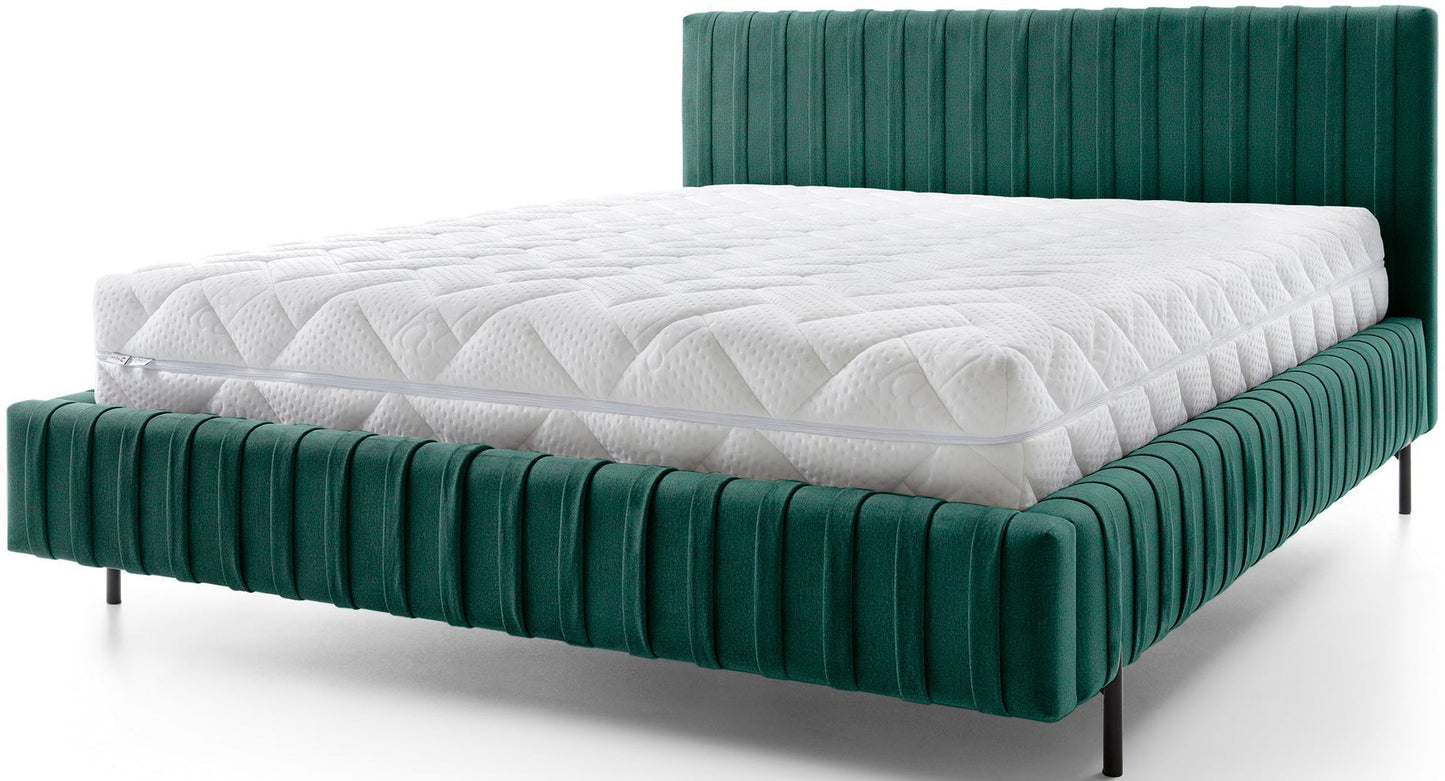 Widok frontowy łóżka Plissa 140×200 w tkaninie Nube 35 zielonej na białym tle, z białym pikowanym materacem i smukłymi czarnymi nogami.