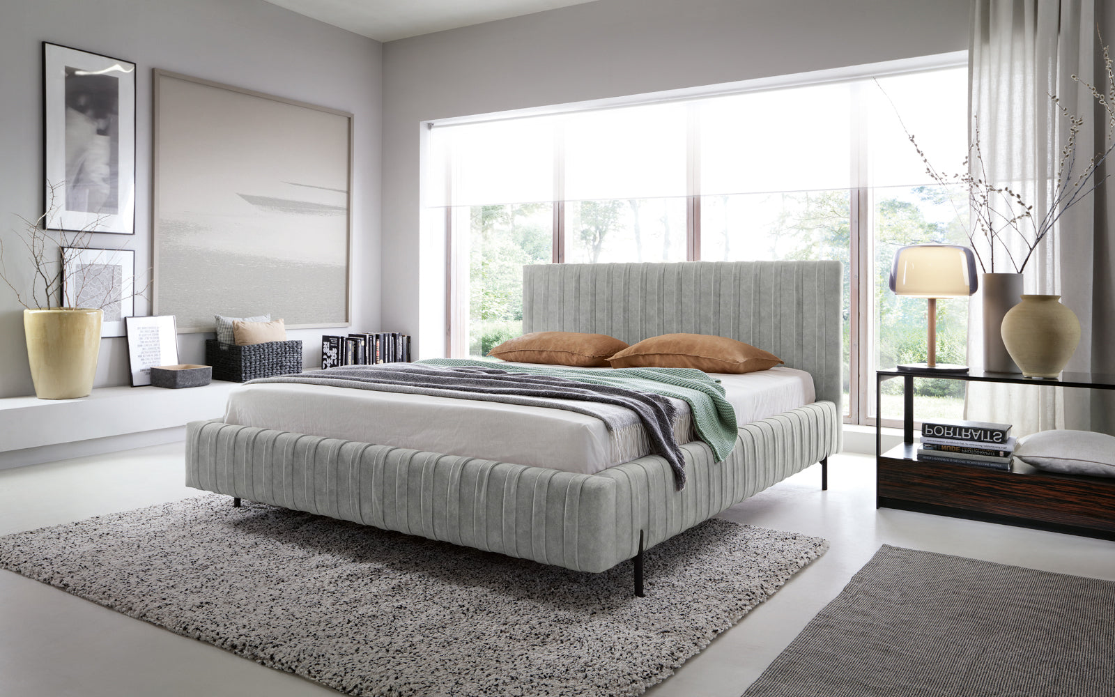 Łóżko Plissa Relax 03 szary 180×200 w stylowej sypialni przy dużym oknie, z beżową pościelą, miętowym pledem i lampką na czarnym stoliku.