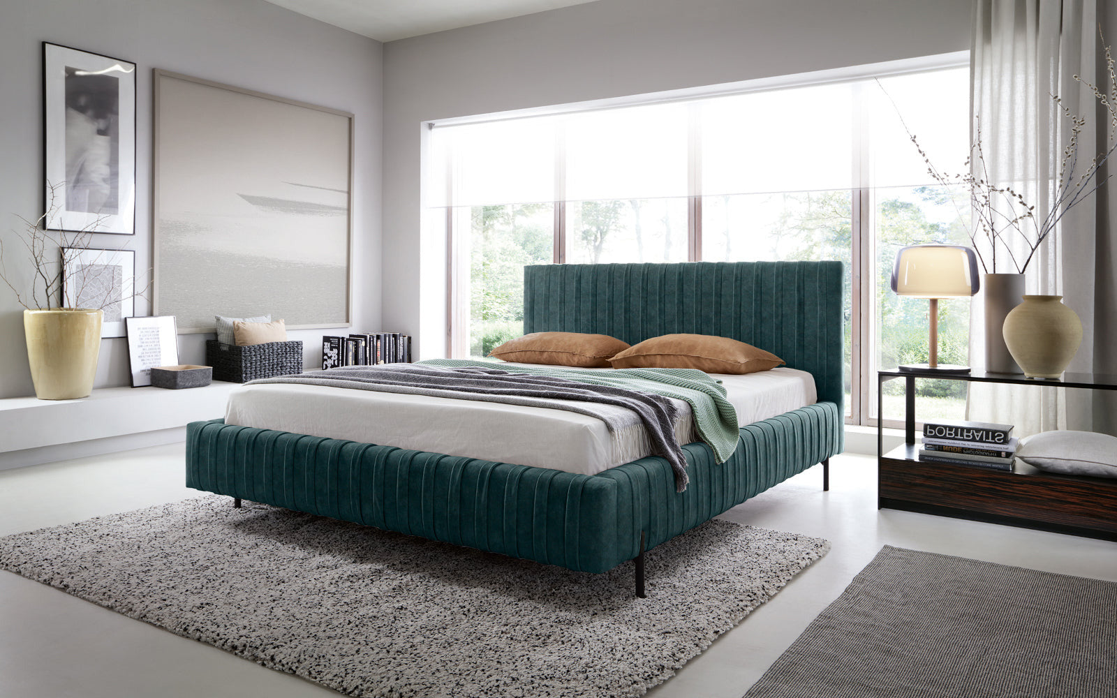 Łóżko Plissa 140×200 w kolorze Relax 38 zielony ustawione na dwuwarstwowym dywanie przed dużym oknem w nowoczesnej sypialni, udekorowane narzutą i poduszkami.