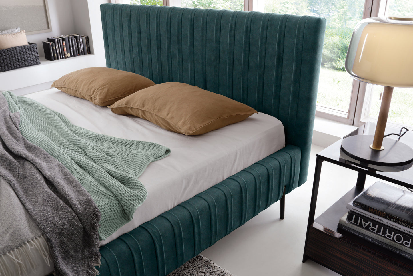 Zbliżenie na wezgłowie i materac łóżka Plissa 140×200 w ciemnozielonej tkaninie Relax 38 z dwiema brązowymi poduszkami obok lampki nocnej.