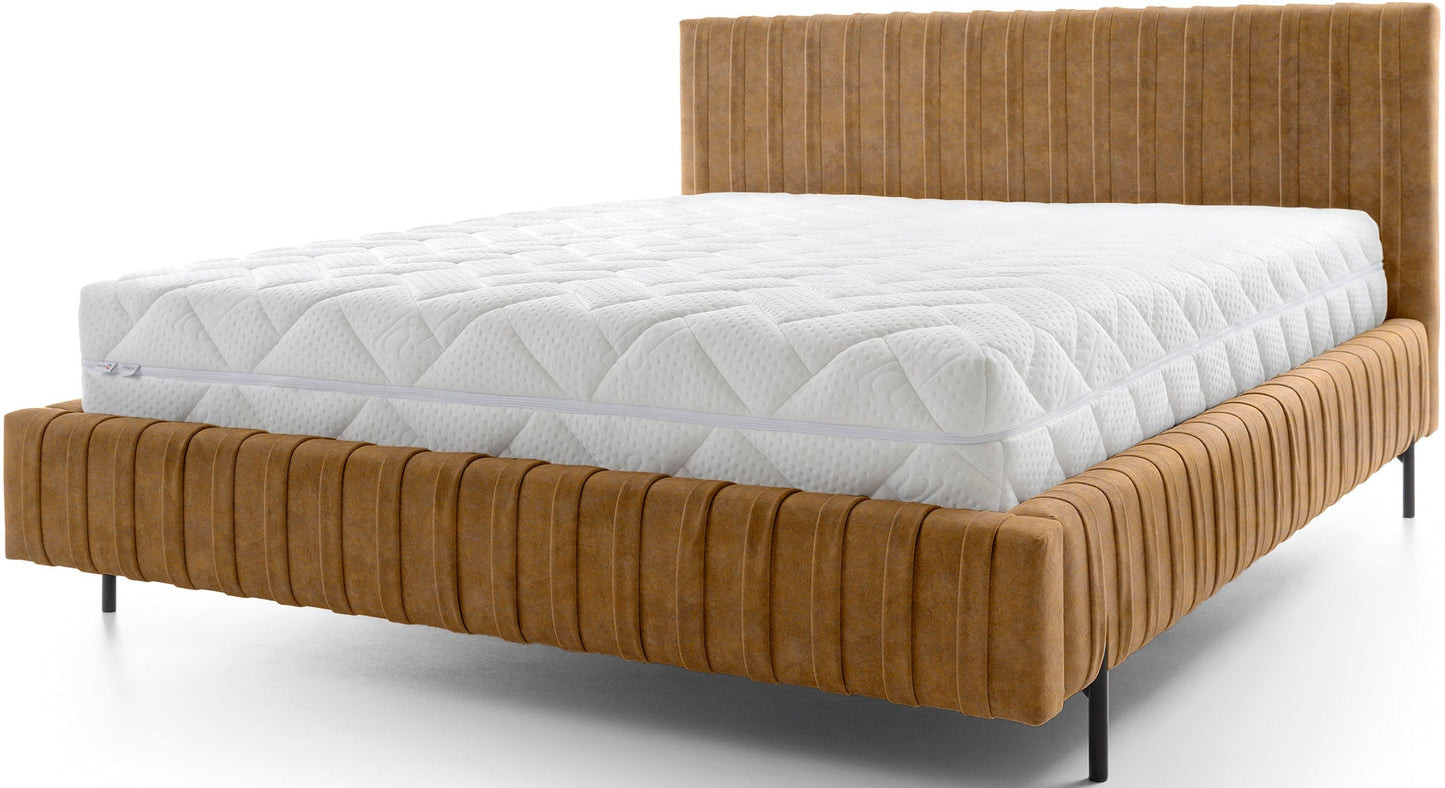 Frontowy widok łóżka Plissa 180×200 w tkaninie Relax 45 żółty na białym tle, z wysokim pikowanym wezgłowiem i smukłymi czarnymi nogami.