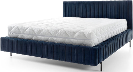 Łóżko Plissa 180×200 Velvetmat 40 granatowy, widok z przodu pod kątem, z białym pikowanym materacem i cienkimi czarnymi nogami na białym tle.