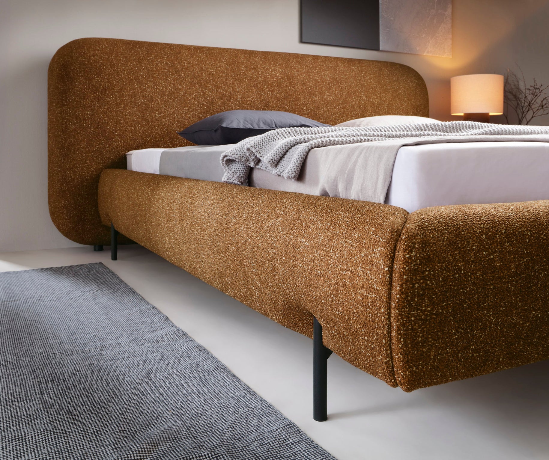 Detal korpusu łóżka Pointt w tkaninie Breona 45 żółty – zaokrąglony kształt, eleganckie wykończenie i solidna konstrukcja na metalowych nogach.