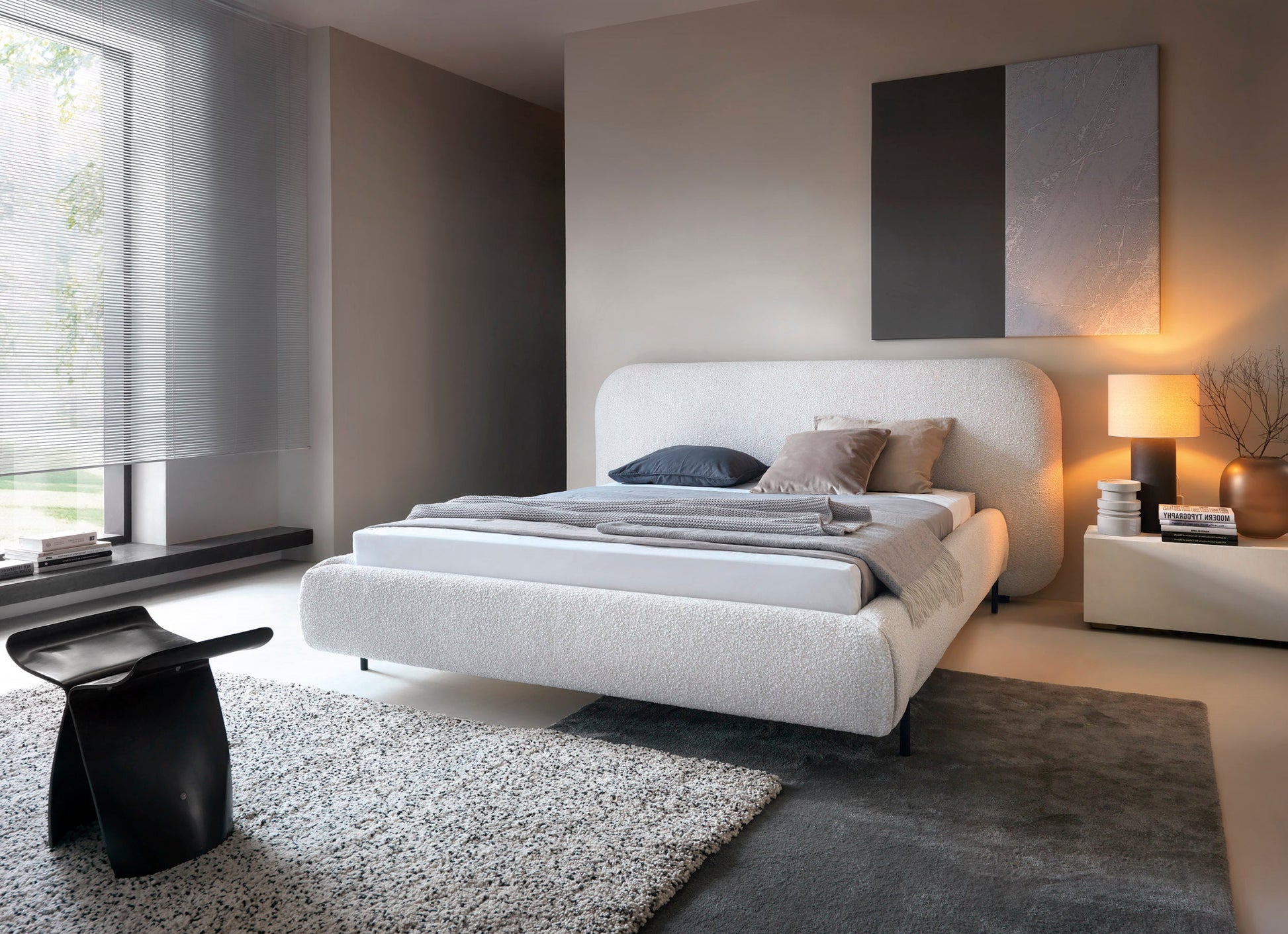 Łóżko Pointt tapicerowane tkaniną boucle Jaffray 18 jasnobeżowy w eleganckiej sypialni – miękka forma, jasna kolorystyka i wygoda. 