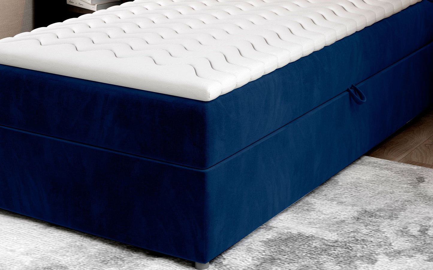 Zbliżenie na dolną część łóżka Rivia w kolorze Kronos 09 granatowy o wymiarach 90x200 cm, z widocznym pojemnikiem na pościel.