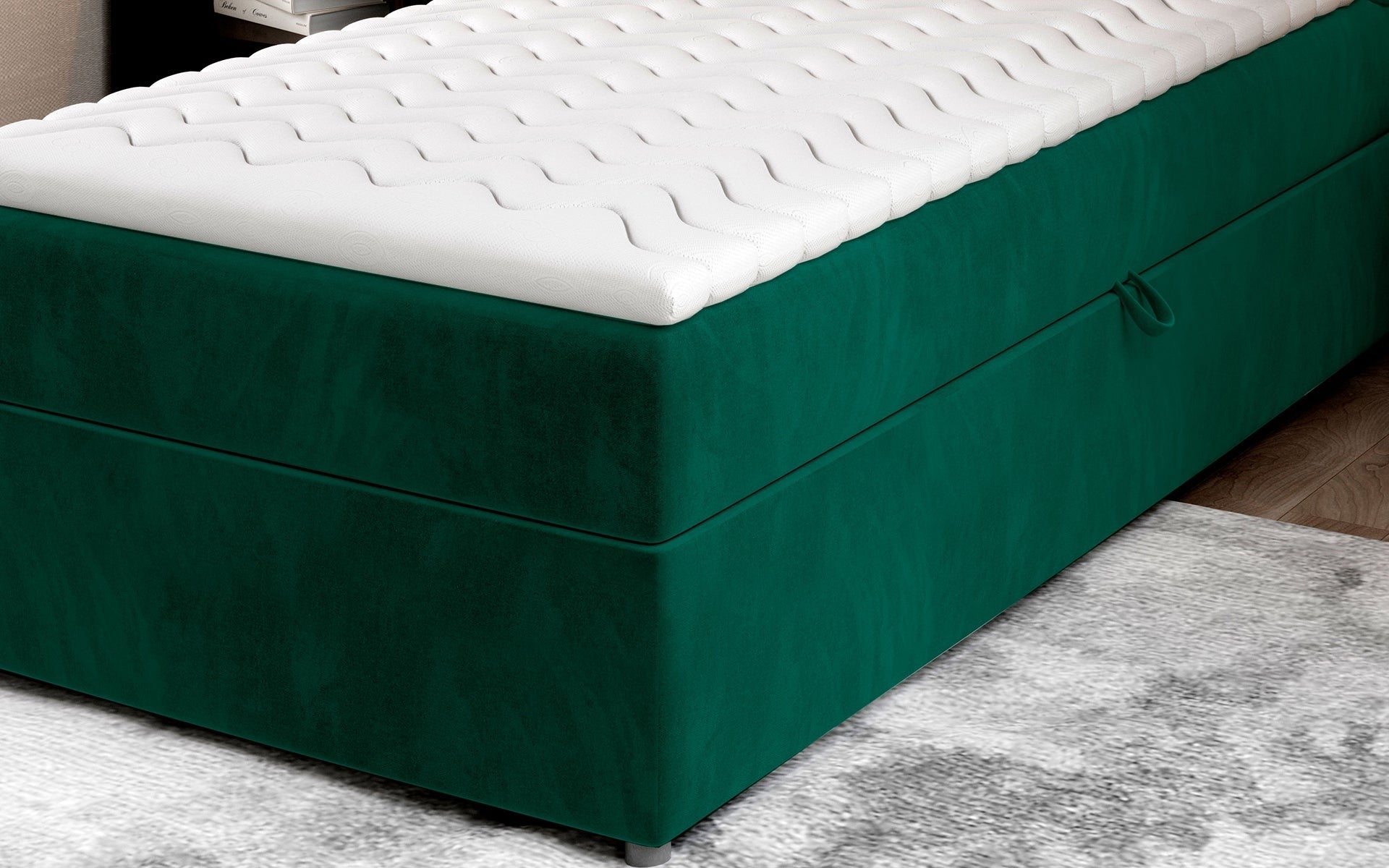 Zbliżenie na dolną część łóżka Rivia w kolorze Monolith 37 butelkowa zieleń o wymiarach 90x200 cm, z widocznym pojemnikiem na pościel.