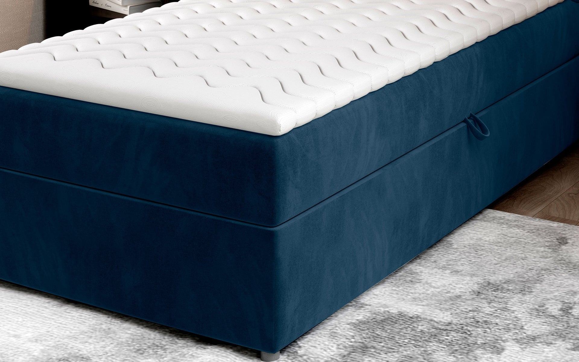 Zbliżenie na dolną część łóżka Rivia w kolorze Monolith 77 granatowy o wymiarach 90x200 cm, z widocznym pojemnikiem na pościel.