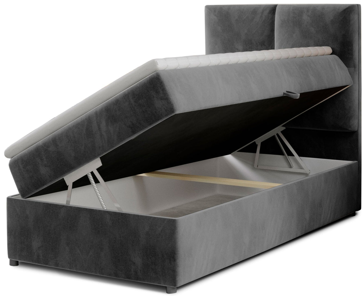 Łóżko Rivia w kolorze Paros 06 ciemnoszary o wymiarach 90x200 cm z podniesionym stelażem i otwartym pojemnikiem na pościel.
