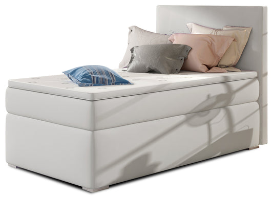 Łóżko kontynentalne Rocco w kolorze Soft 17 biały, układ lewy – widok studyjny z przodu, prezentujące eleganckie, tapicerowane wykończenie i nowoczesny zagłówek w jasnej tkaninie.