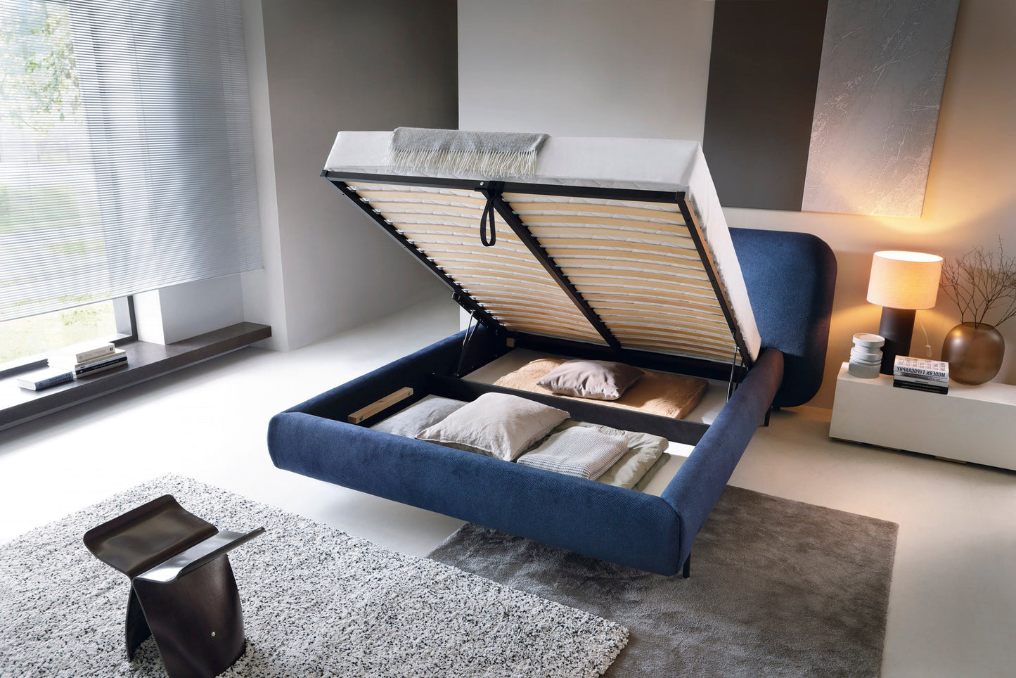 Otwarte niebieskie łóżko tapicerowane Paoli 160×200 cm z pojemną skrzynią na pościel w nowoczesnej sypialni