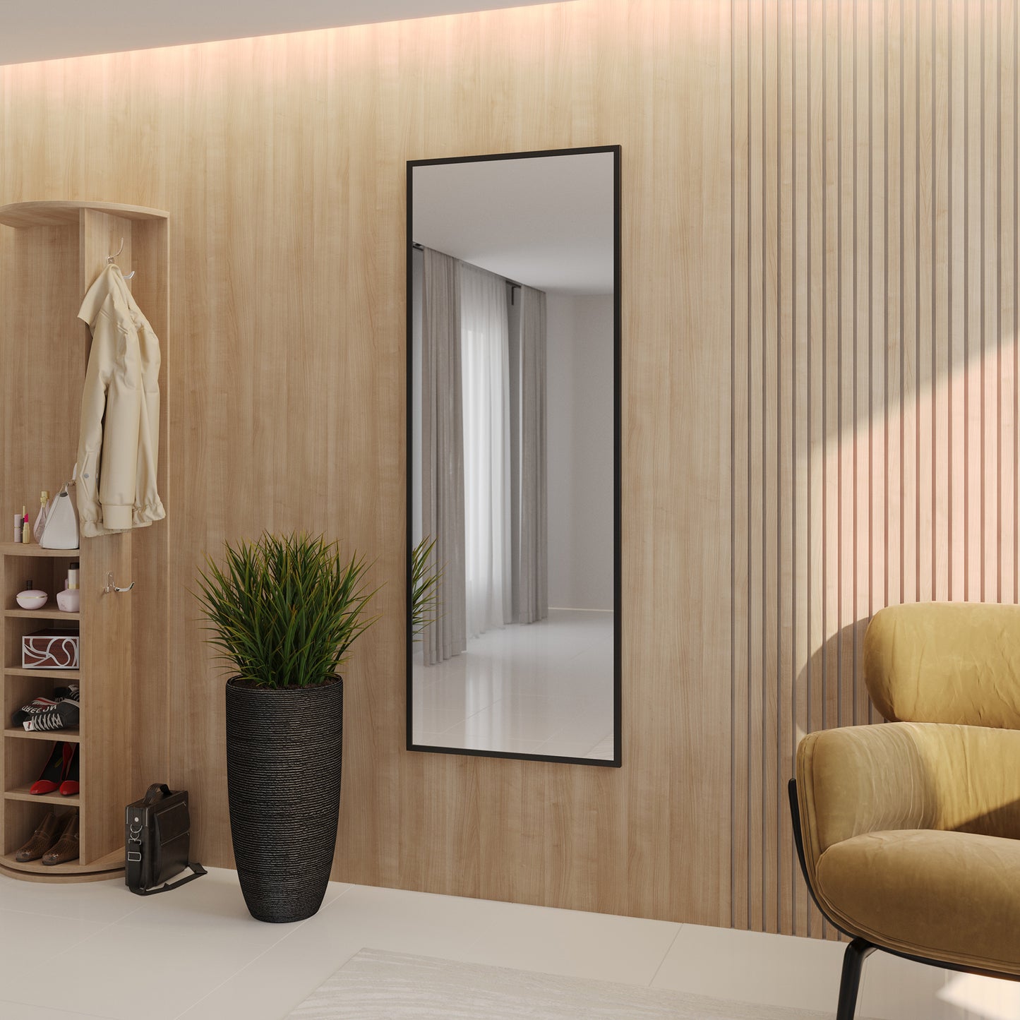 Lustro Aruba czarne – aranżacja w przedpokoju – wysokie prostokątne lustro w czarnej ramie zawieszone na jasnej ścianie, obok wieszaka i fotela.