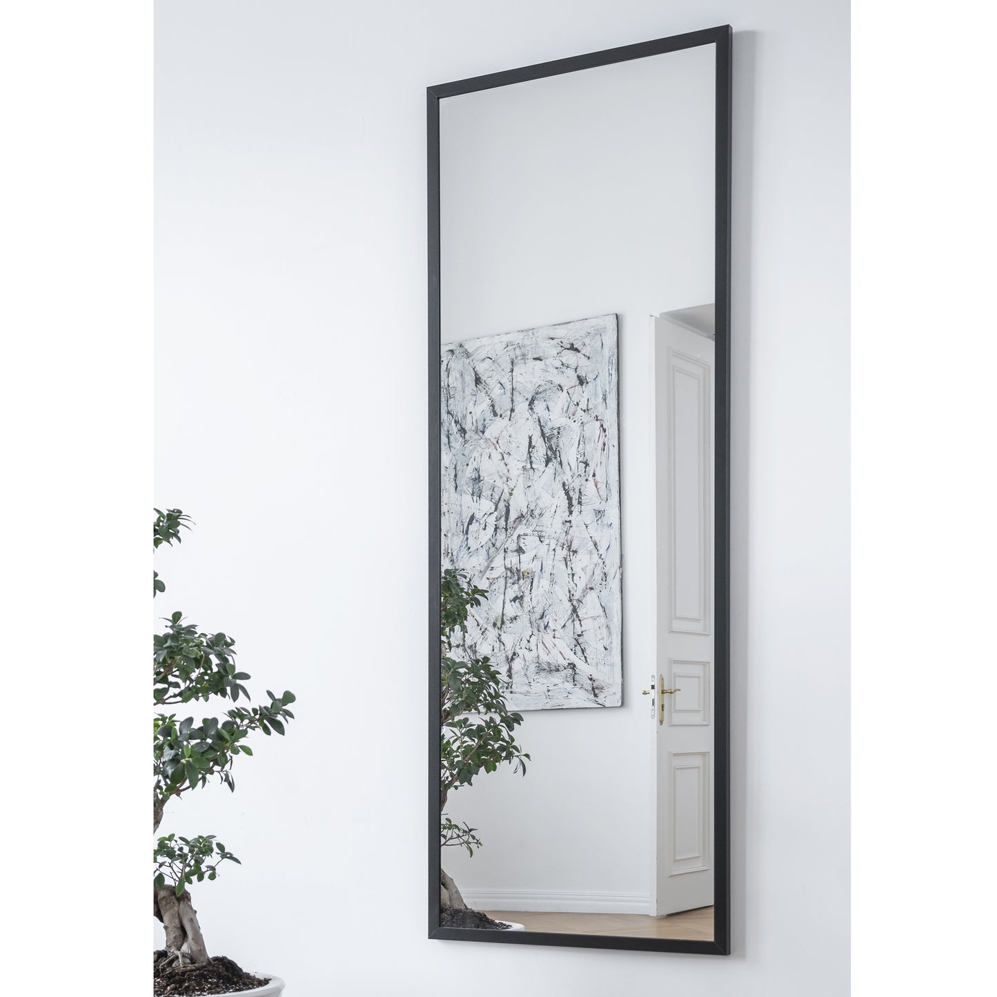 Lustro Aruba w kolorze czarnym – aranżacja w nowoczesnym wnętrzu – duże prostokątne lustro w czarnej ramie umieszczone na ścianie obok dekoracji i obrazu.