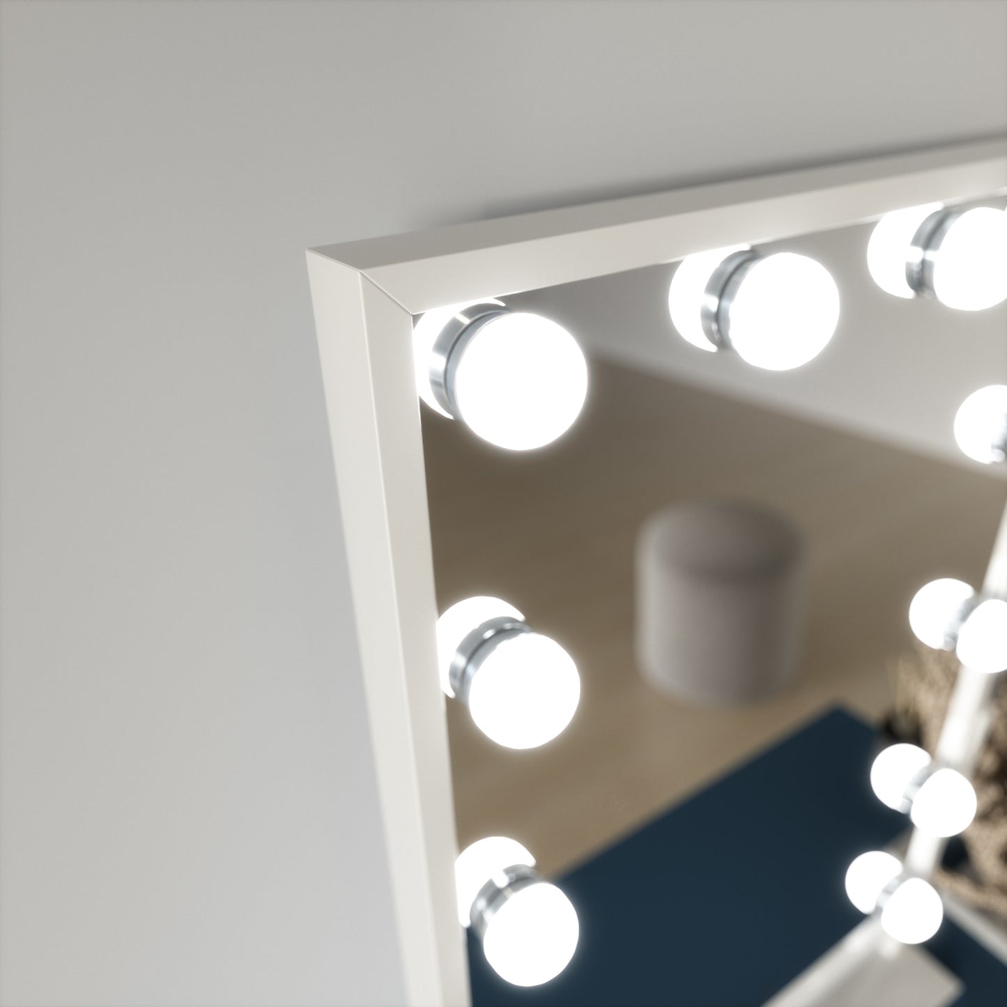 Zbliżenie górnego lewego narożnika lustra Flamnate z białą ramą i kulistą żarówką, na tle rozmytego wnętrza.