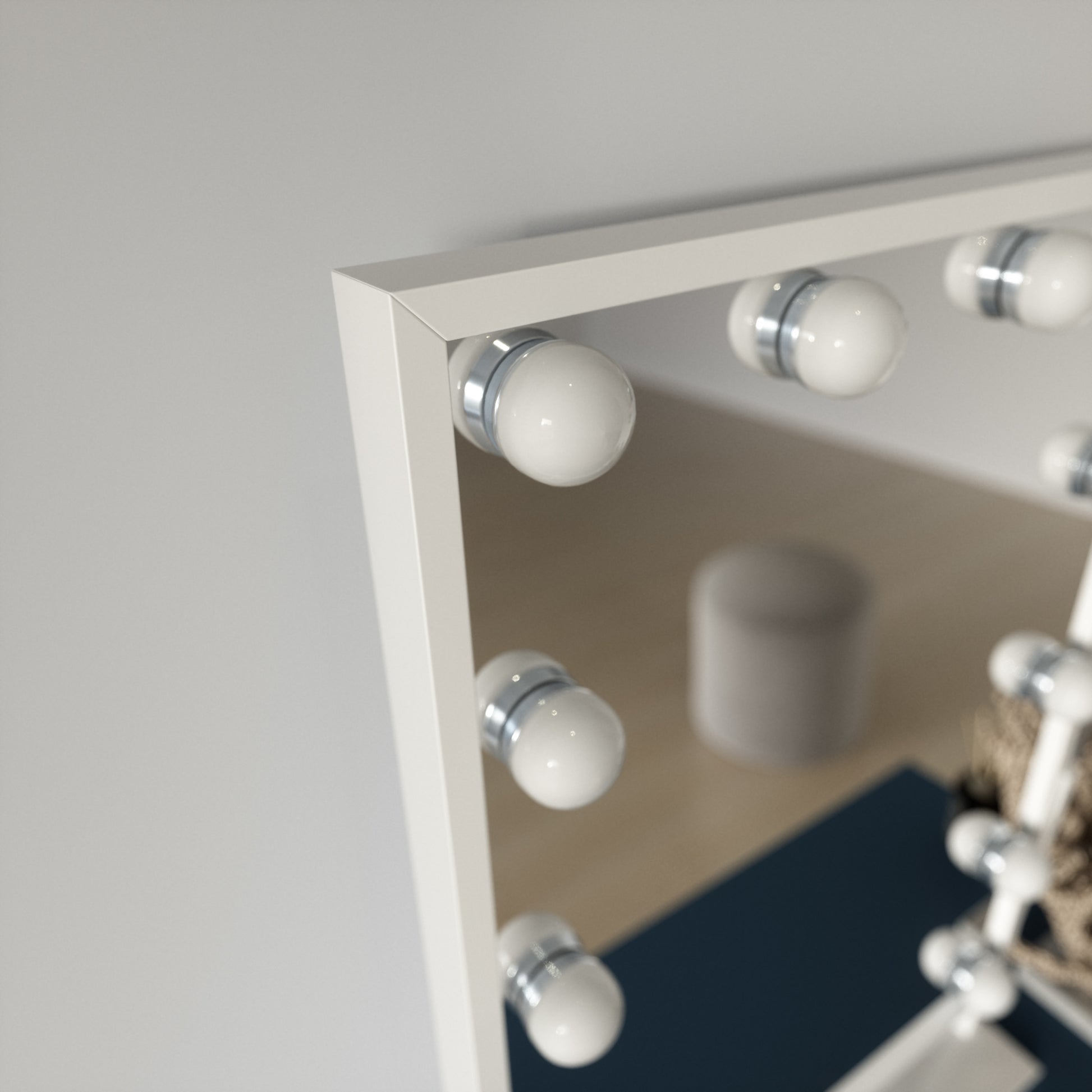 Detal białej ramy lustra Flamnate 30×47 cm z widoczną chromowaną oprawką kulistej żarówki.