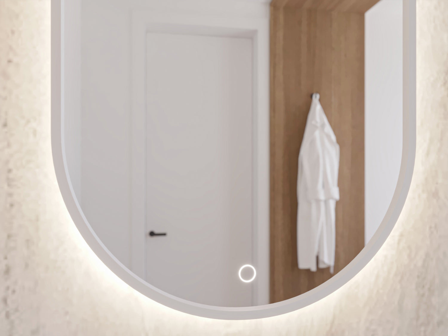 Zbliżenie dolnej części białego, owalnego lustra Arducati A 50×100 cm z widocznym okrągłym przyciskiem dotykowym i odbiciem białego szlafroka.