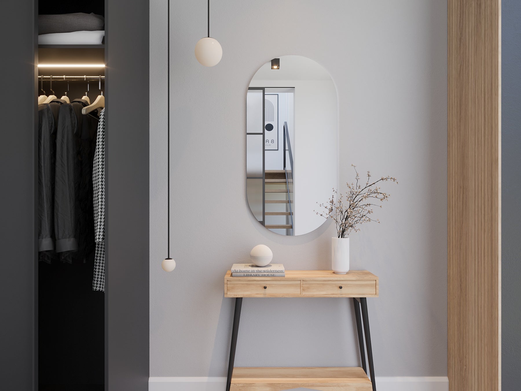 Białe owalne lustro Nunisse 50×100 cm zawieszone nad drewnianą konsolą w przedpokoju, obok otwartej szafy wnękowej.