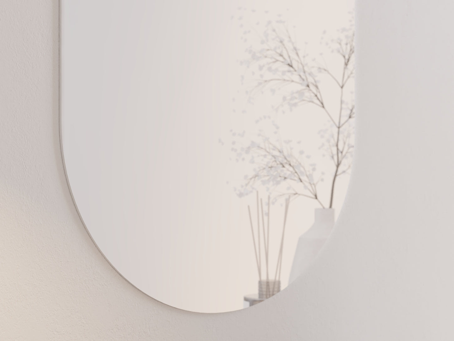 Zbliżenie dolnej części białego owalnego lustra Nunisse 50×100 cm z odbiciem roślinnego motywu na ścianie.