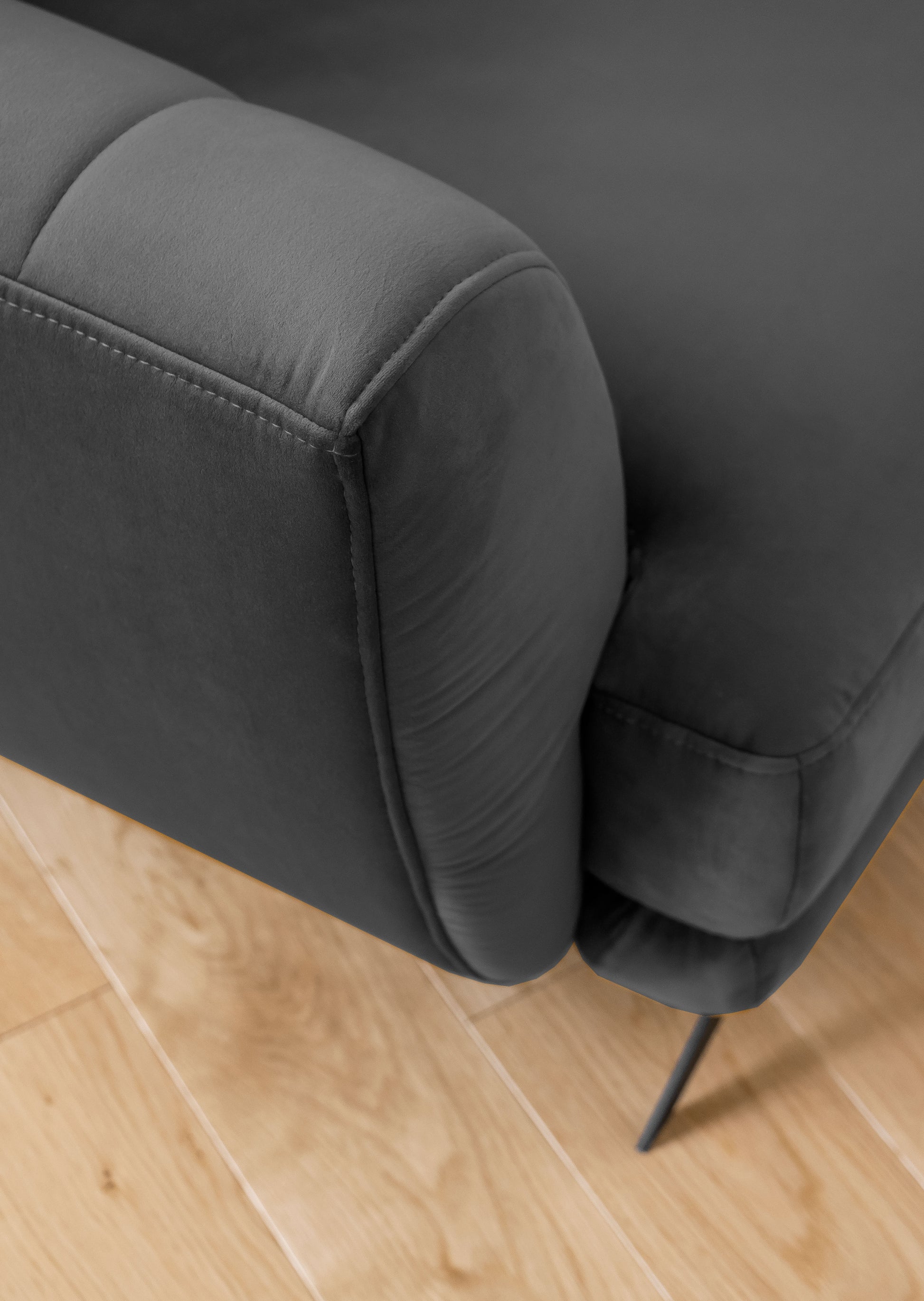 Elegancki zestaw sofa, fotel i pufa Megis w tapicerce velvet. Ciemnoszary kolor nadaje wnętrzu ponadczasowy i uniwersalny charakter.

