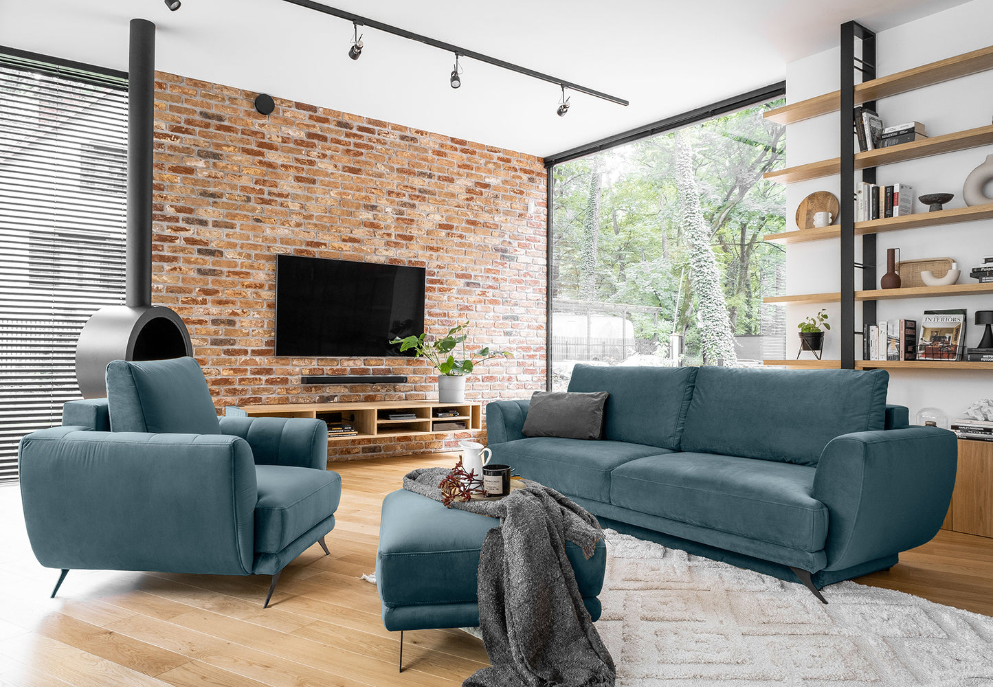 Zestaw Megis Loco 38 w pastelowym odcieniu niebieskiego składa się z sofy, fotela i podnóżka. Harmonijna kolorystyka i zaokrąglone bryły tworzą spójną, designerską kompozycję.
