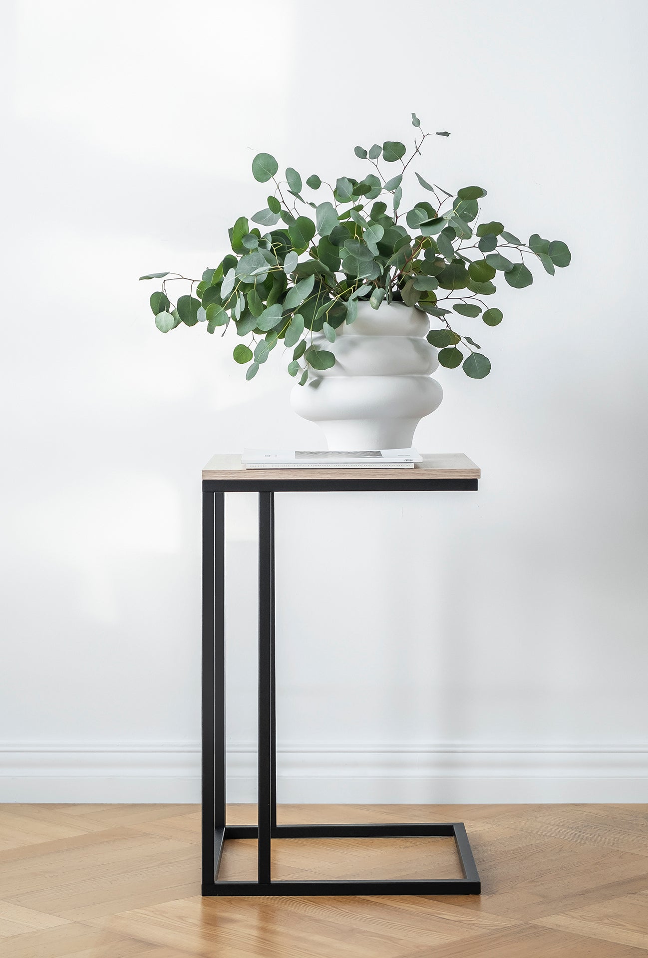 Stolik do salonu Vigo z drewnianym blatem i prostą metalową ramą. Minimalistyczny design pasuje do nowoczesnych przestrzeni mieszkalnych.

