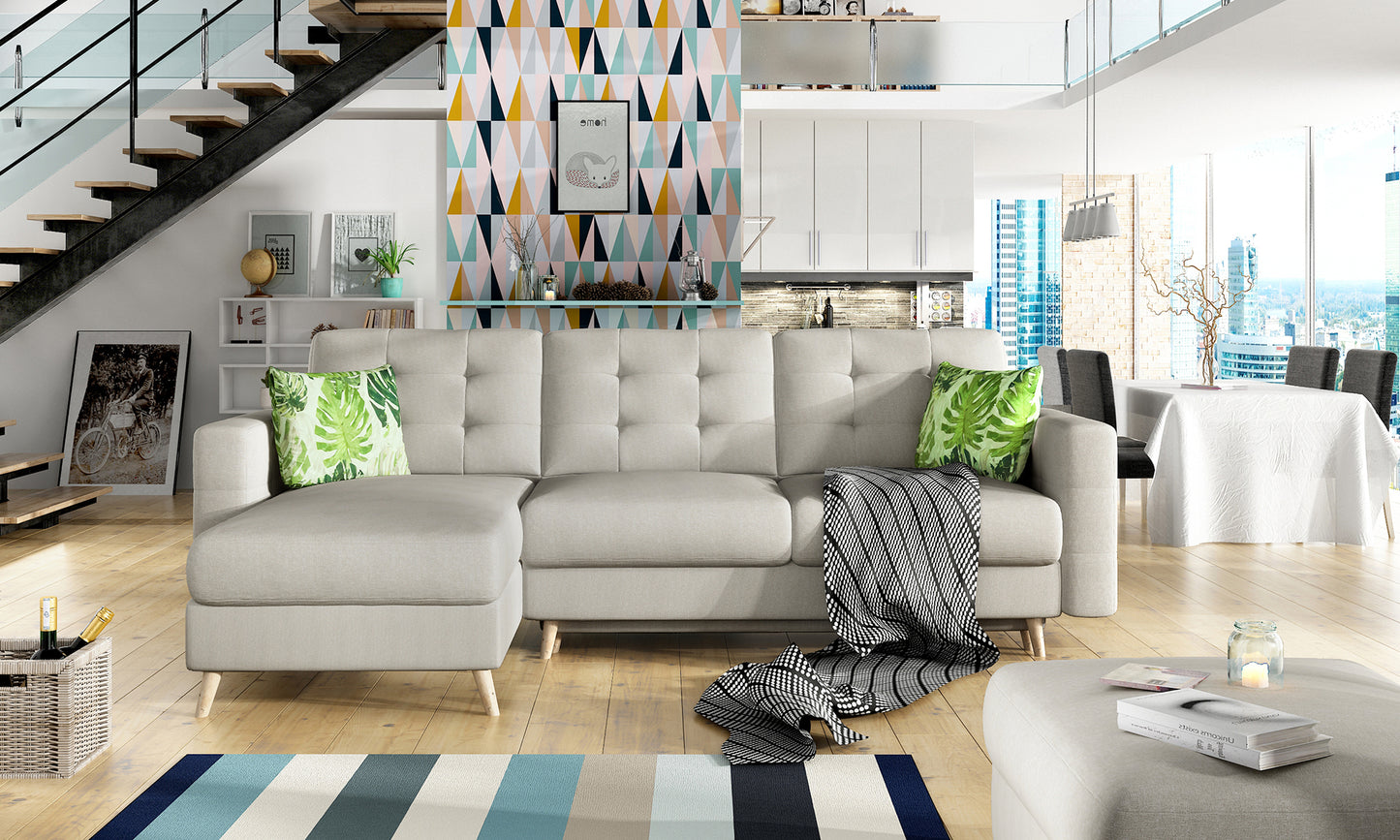 Jasnoszary narożnik Asgard L Cover 02 z zielonymi poduszkami Jungle 32 ustawiony w nowoczesnym salonie z geometryczną tapetą i widokiem na miasto, wyeksponowany centralnie.